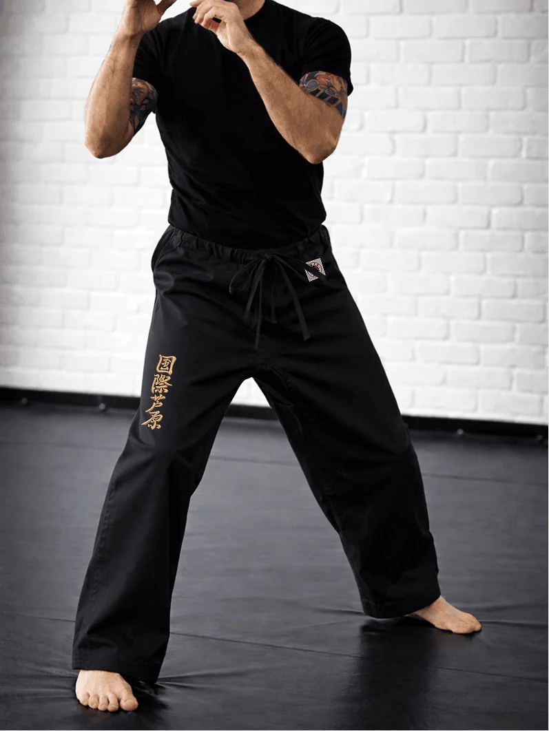 Чёрная модель AIKO М2 на спортсмене: точная длина до щиколотки, золотая вышивка и фирменная жаккардовая маркировка