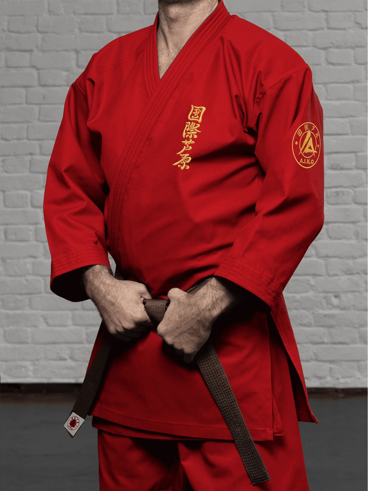 Красная куртка AIKO К1 «Наследие» на спортсмене: золотой кандзи, золотая канку A.I.K.O. и выразительная вышивка на плече