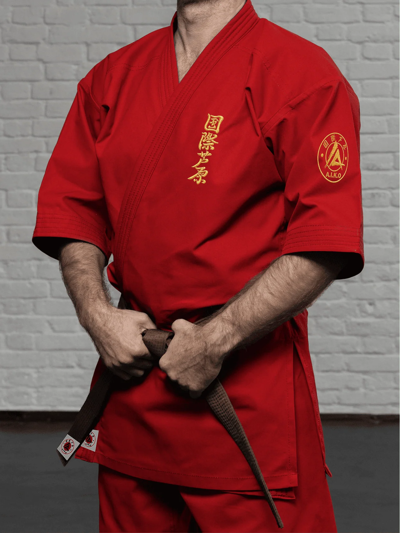 Красная куртка AIKO К2 «Наследие» на спортсмене: укороченный рукав ниже локтя, золотой кандзи и золотая канку A.I.K.O.