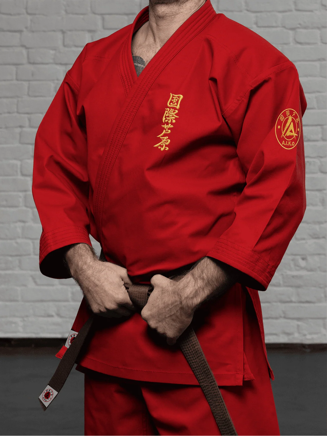 Красная куртка AIKO К3 «Наследие» на спортсмене: длинный рукав до запястья, золотой кандзи и золотая канку A.I.K.O.