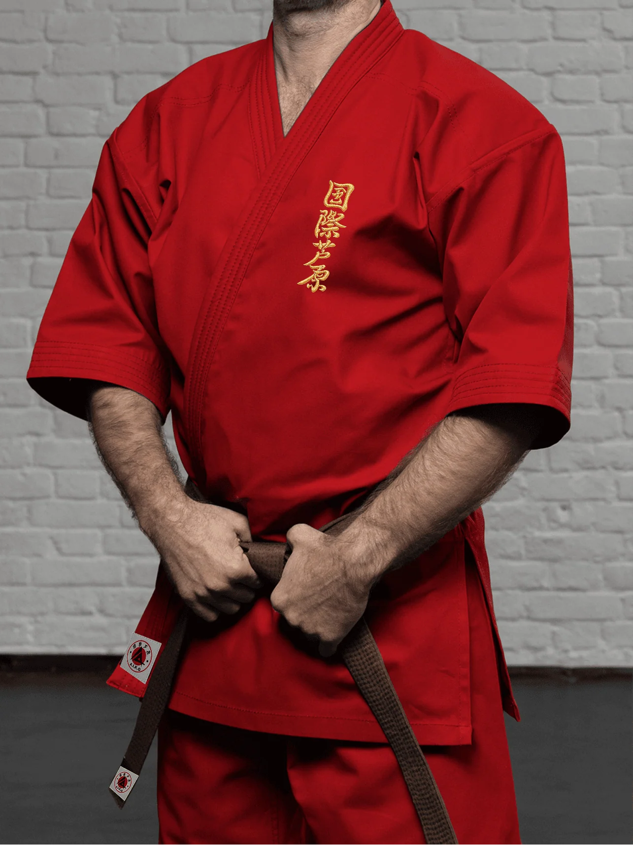 Красная куртка AIKO К4 «Стандарт» на спортсмене: золотой кандзи на груди, укороченный рукав ниже локтя и чистая линия плеча