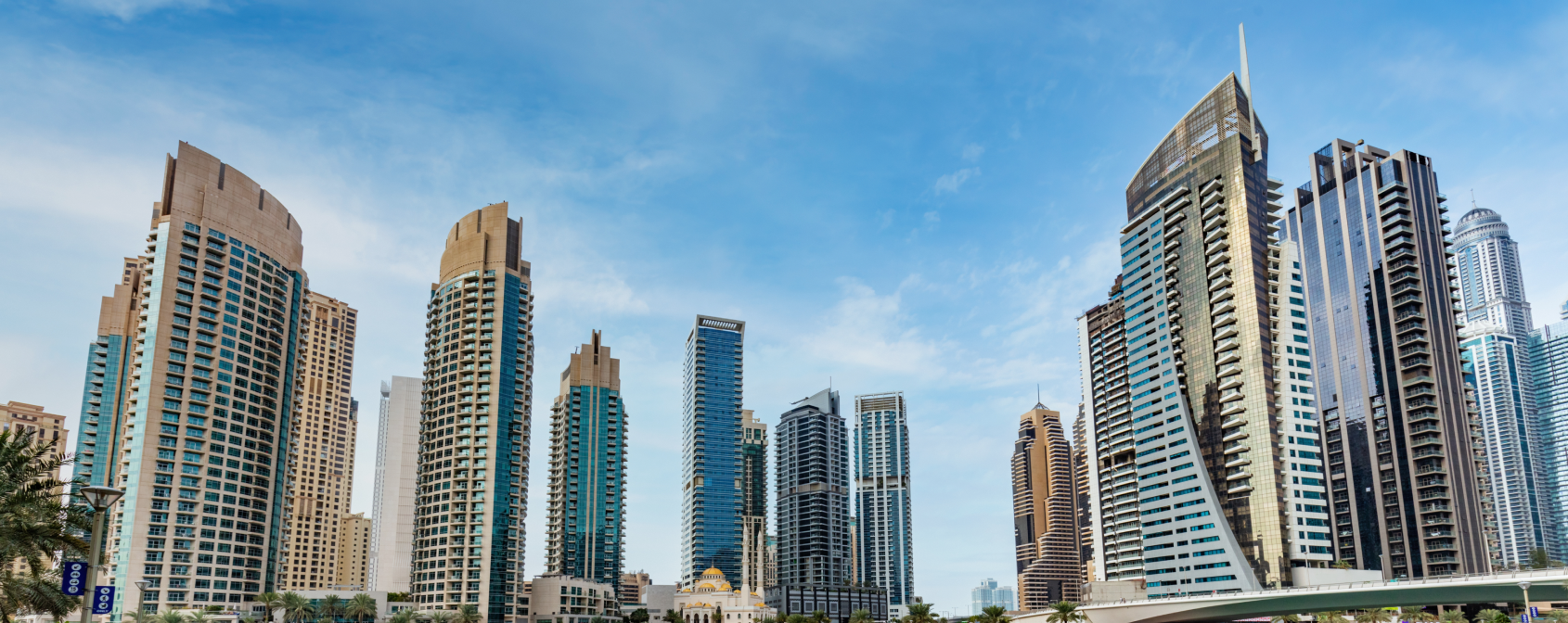 Skyline of modern high-rise buildings in Dubai under a blue sky with a text box about Dubai's ultra-liquid market options.