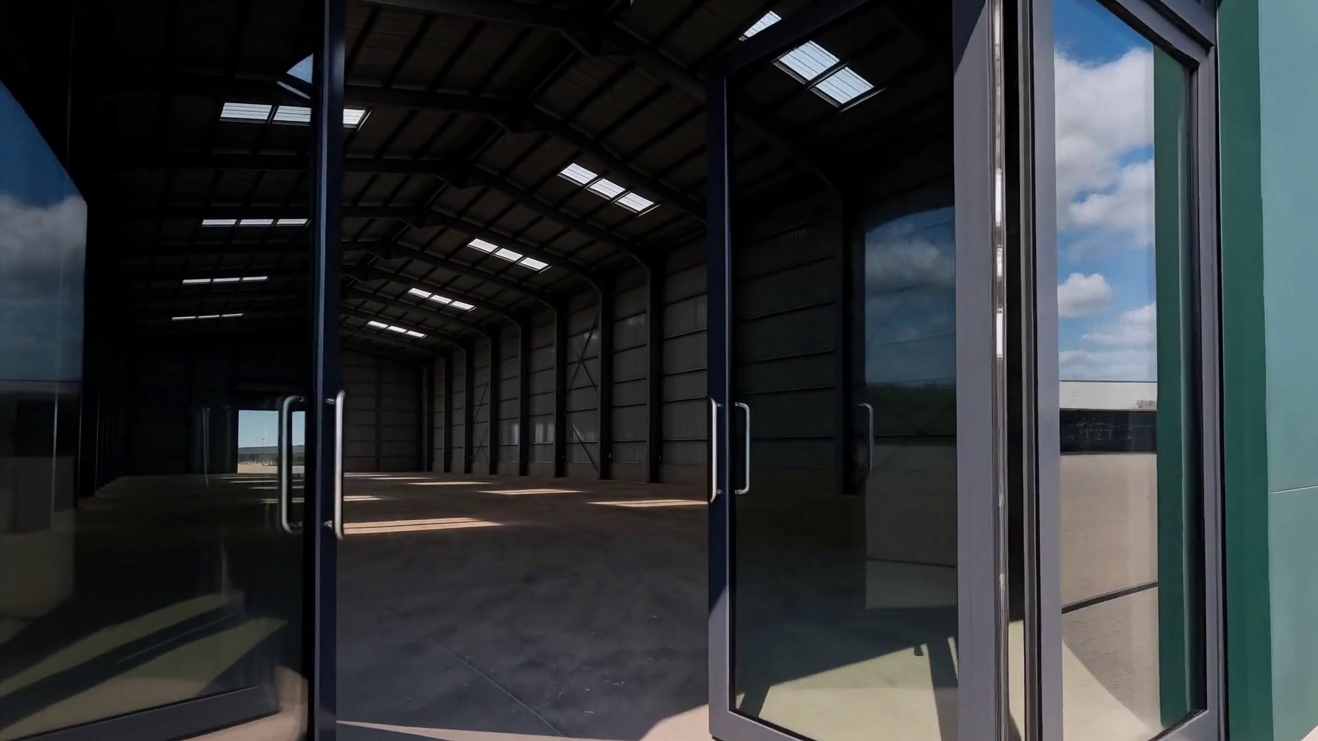 Glass doors opening into an empty warehouse hall