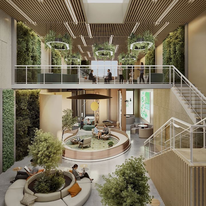 A two-storey atrium lounge with planted walls, a mezzanine meeting floor and a sunken seating circle.