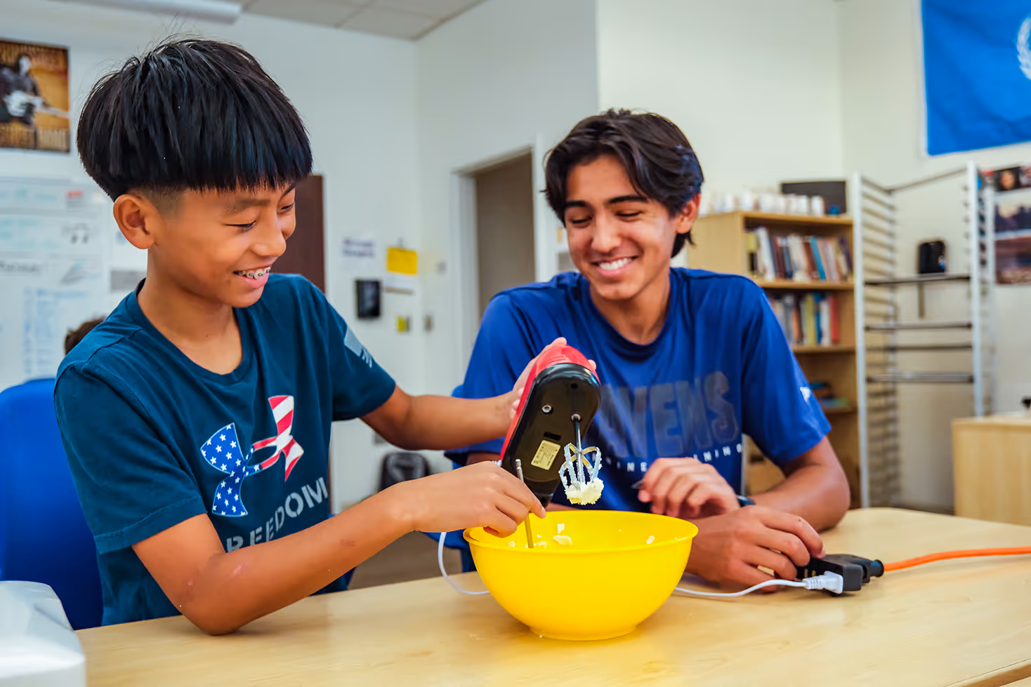 Cary Academy students collaborating and laughing while mixing ingredients during X-Day hands-on learning activity.