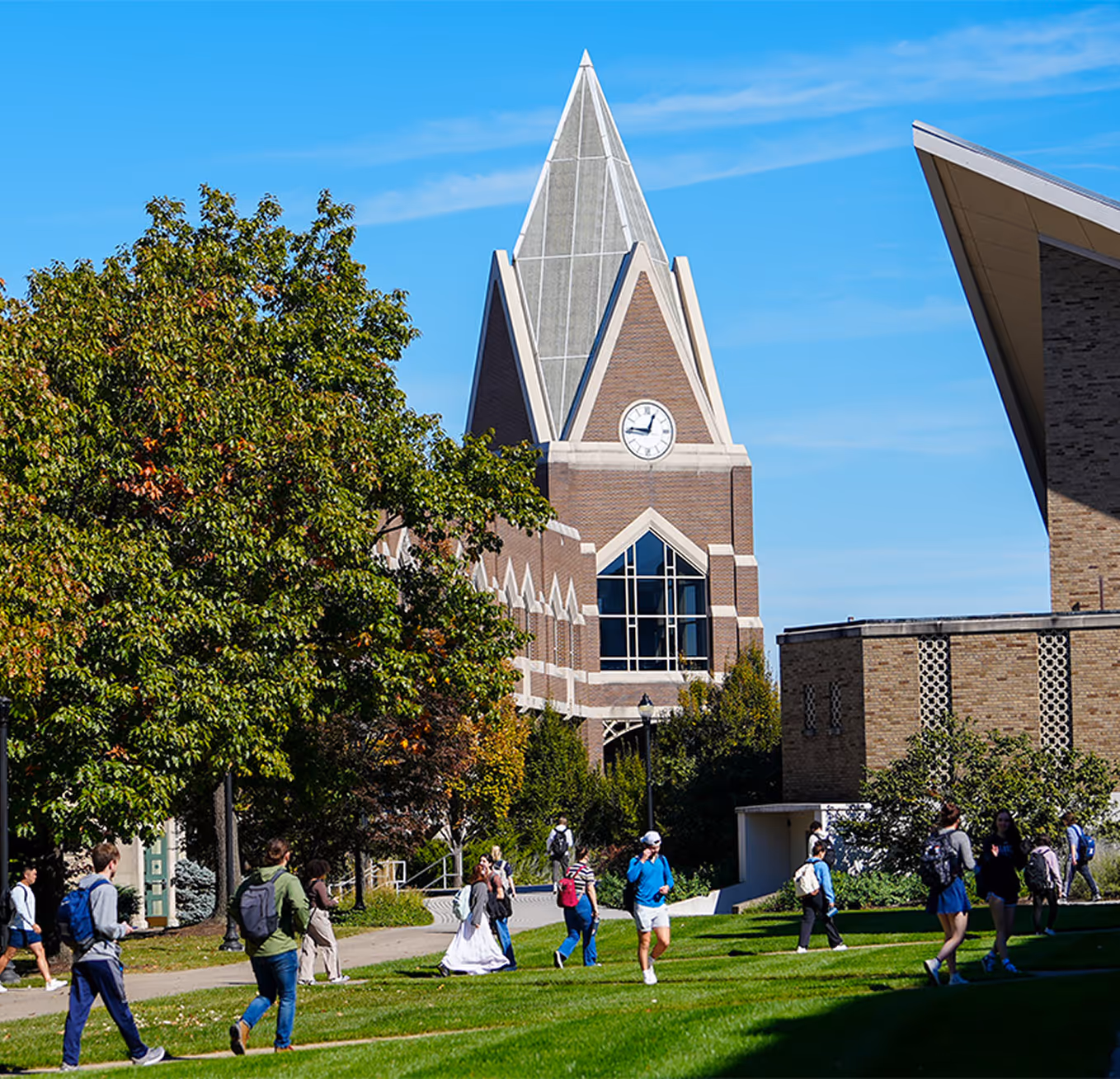 Students walk on a green campus lawn at Xavier University