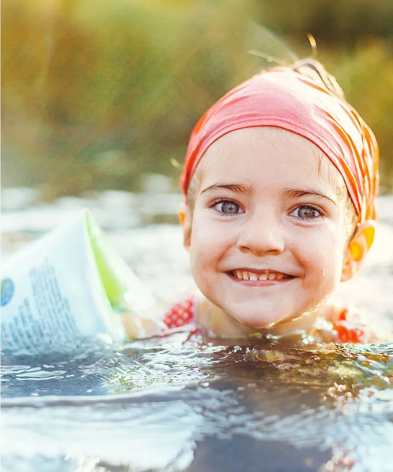 A young girl swimming with a floatie 