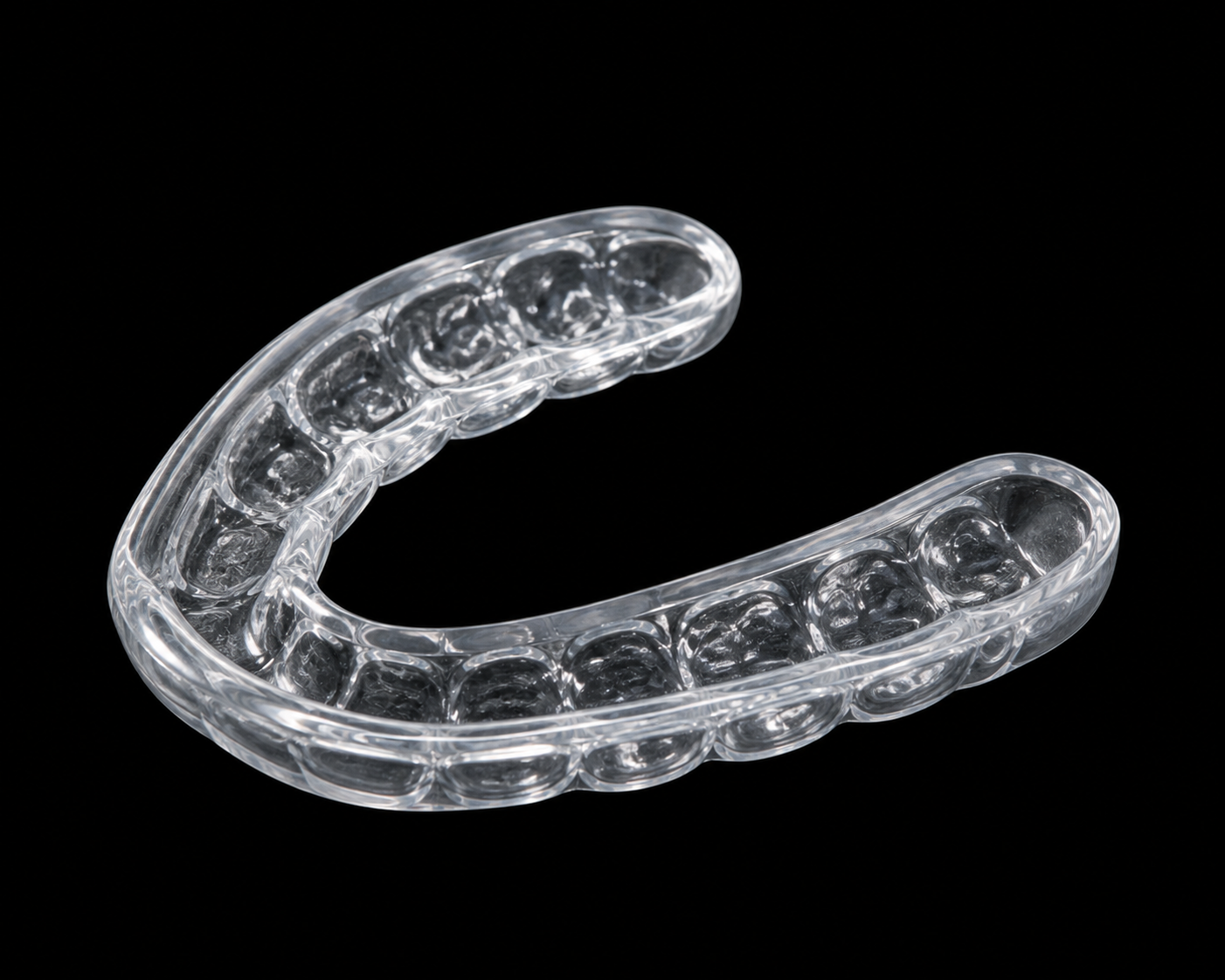 Clear transparent dental night guard on a black background.