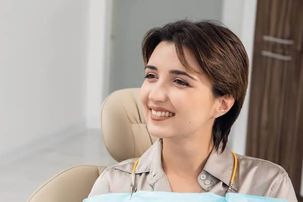 A woman sitting in a chair smiling at the camera.