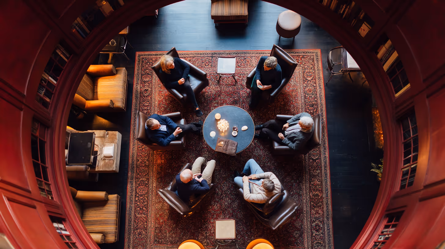Overhead view of round dinner table with guests in conversation