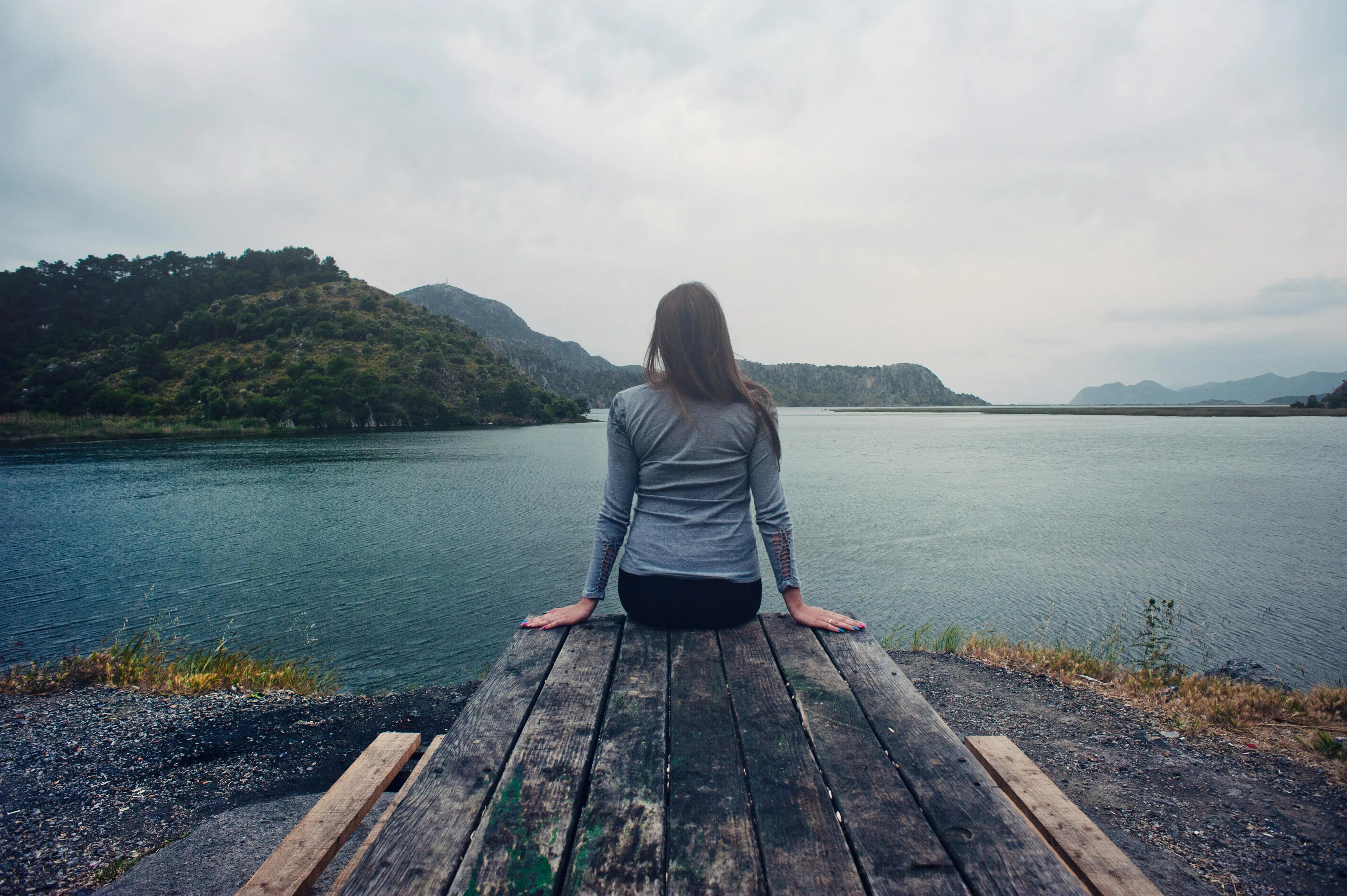 Person sitting looking at lake