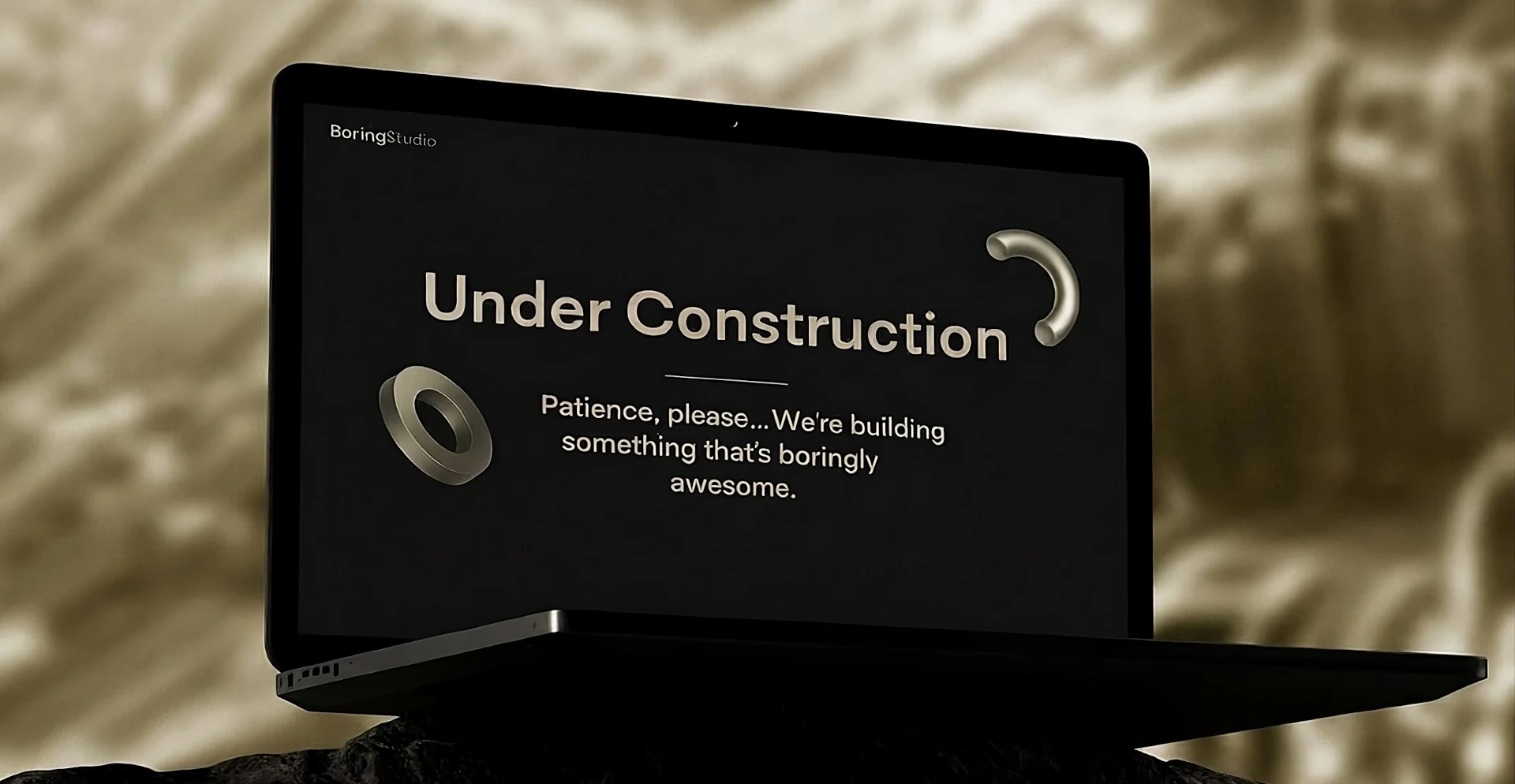 Laptop displaying an "Under Construction" page for Boring Studio.
