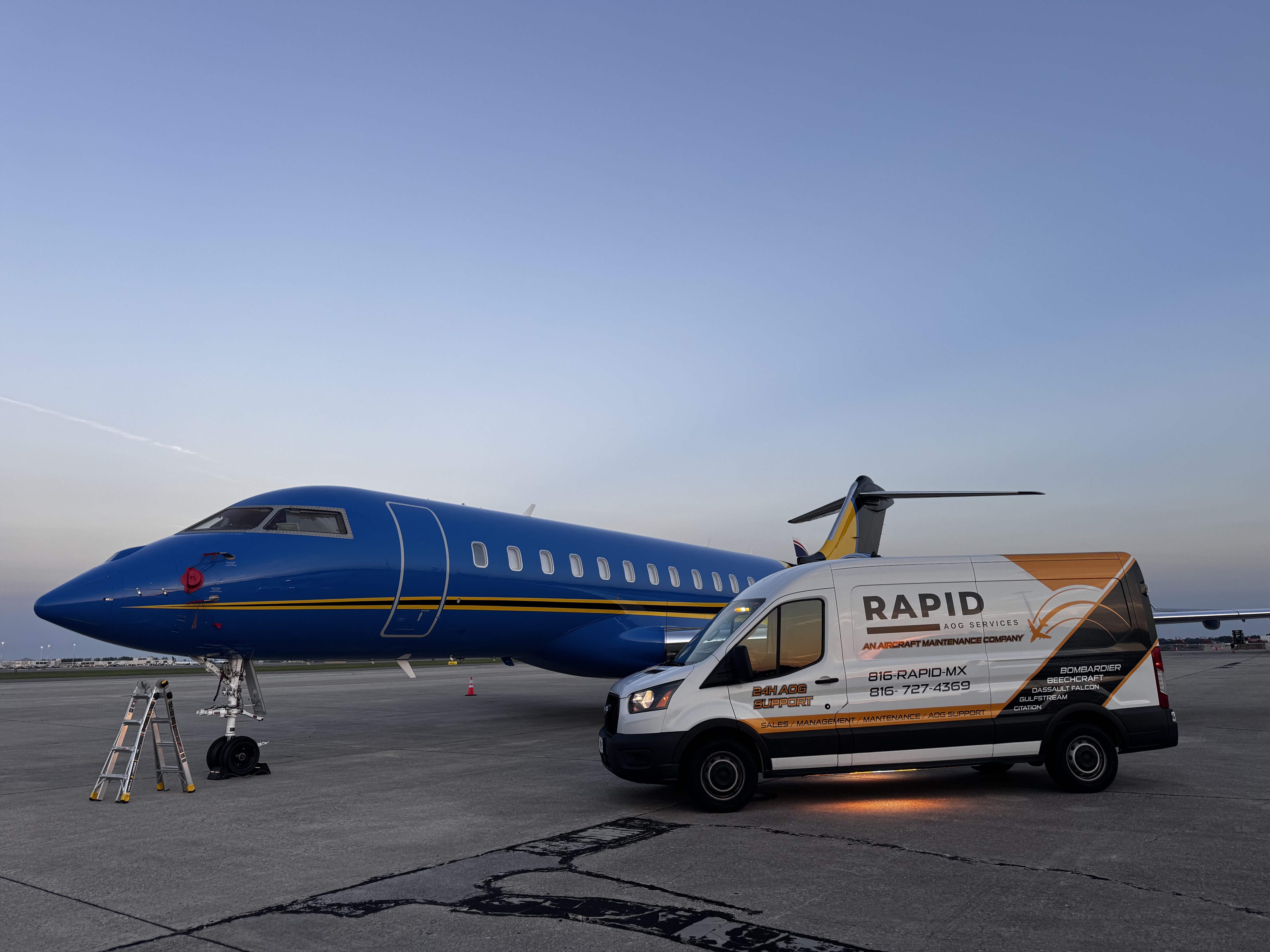 Blue private jet parked on tarmac beside a white van with Rapid AOG Services branding and contact information.
