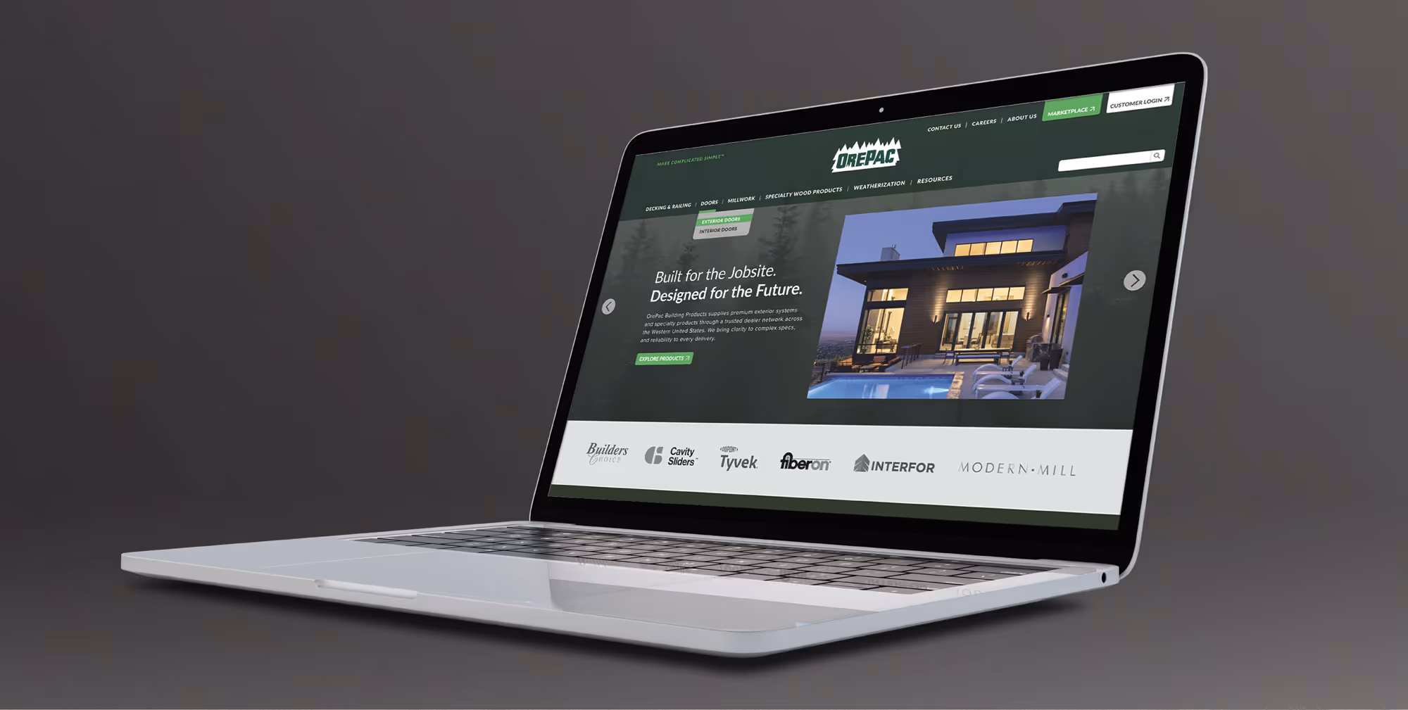 Open laptop displaying Orepac website homepage with modern house image and navigation menu.
