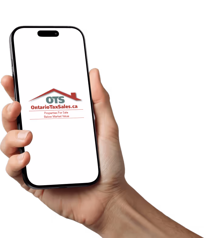 Hand holding a smartphone displaying the logo and text for OntarioTaxSales.ca, advertising properties for sale below market value.