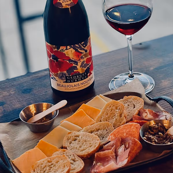 charcuterie board with a glass of wine and a bottle of wine