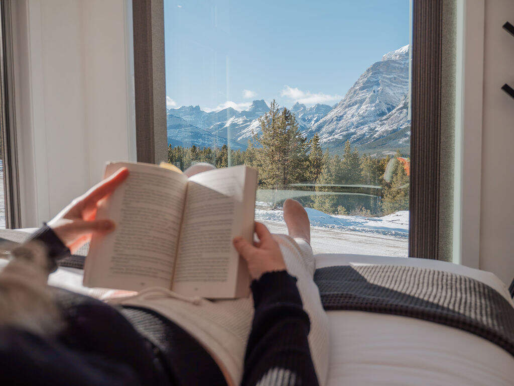 person reading a book on a bed in a SkyBox