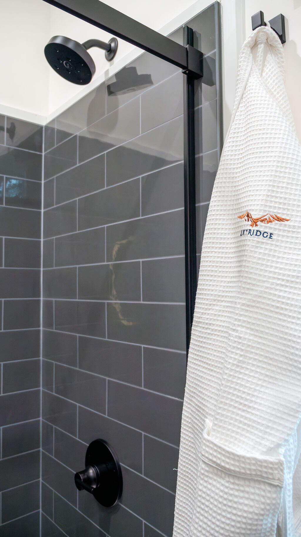 shower with a robe beside it
