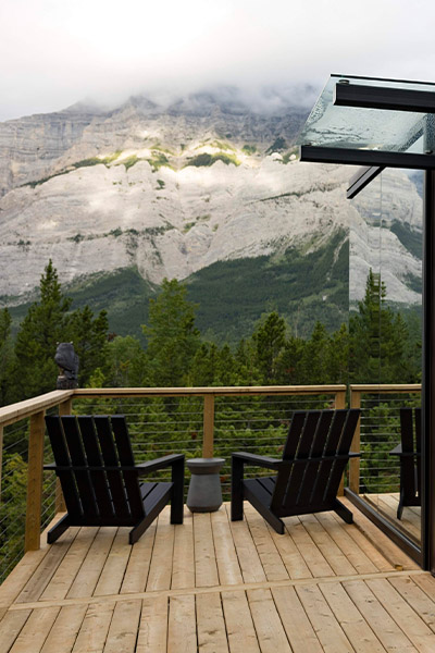 two chairs set up on the balcony of a cabin