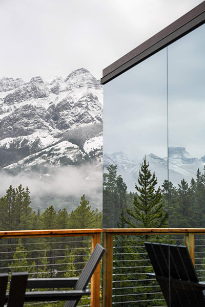 reflective mirrors on the outside of a cabin showing mountains
