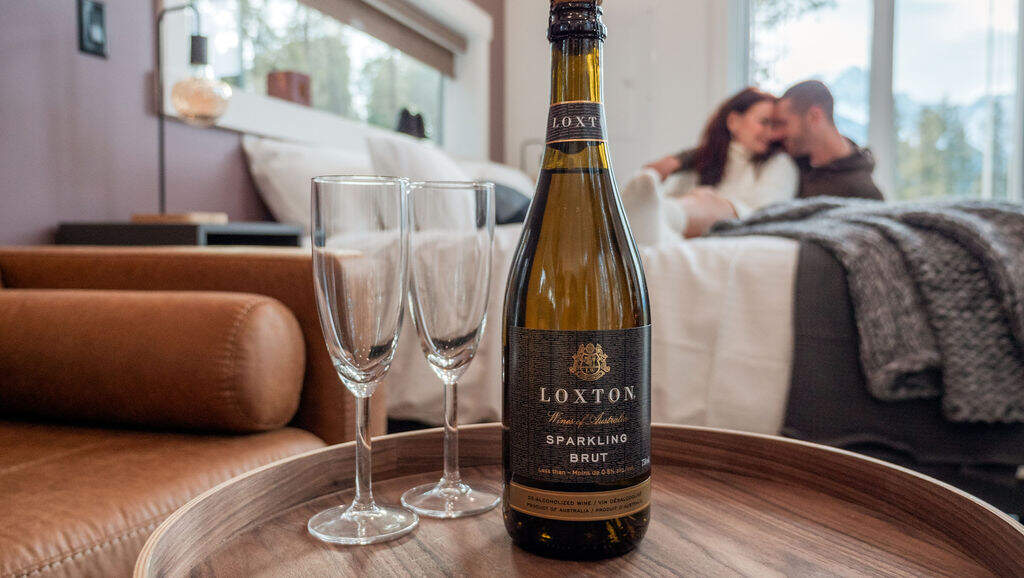 Couple in bed with champagne on table