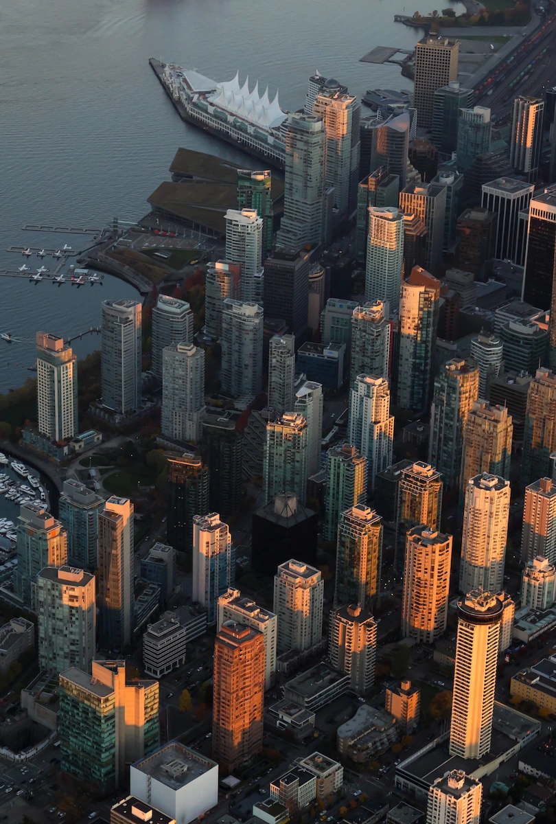 Aerial view of a dense urban downtown area near a waterfront — West Coast City Guides