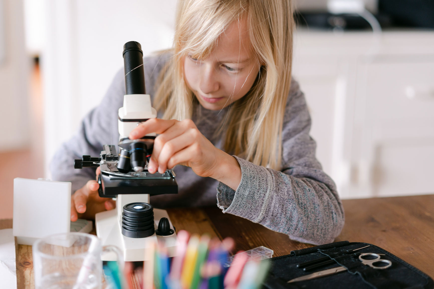 Young student using microscope in science learning activity
