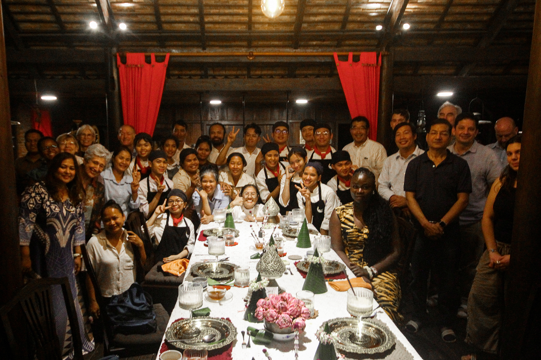Audience at a panel discussion event on Cambodia's digital future, seated facing a stage with a speaker at a podium and large screens displaying panel information.