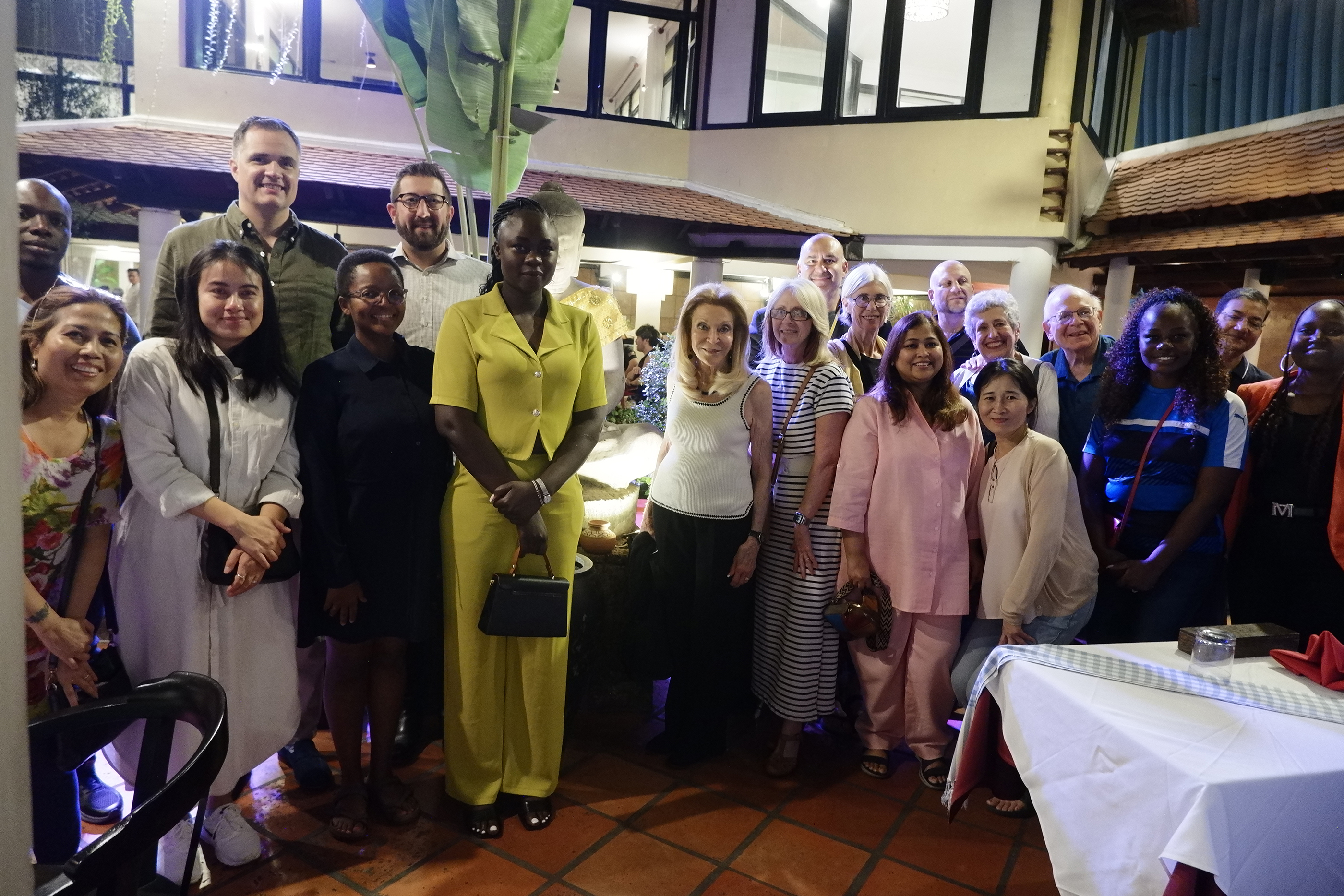 Audience at a panel discussion event on Cambodia's digital future, seated facing a stage with a speaker at a podium and large screens displaying panel information.