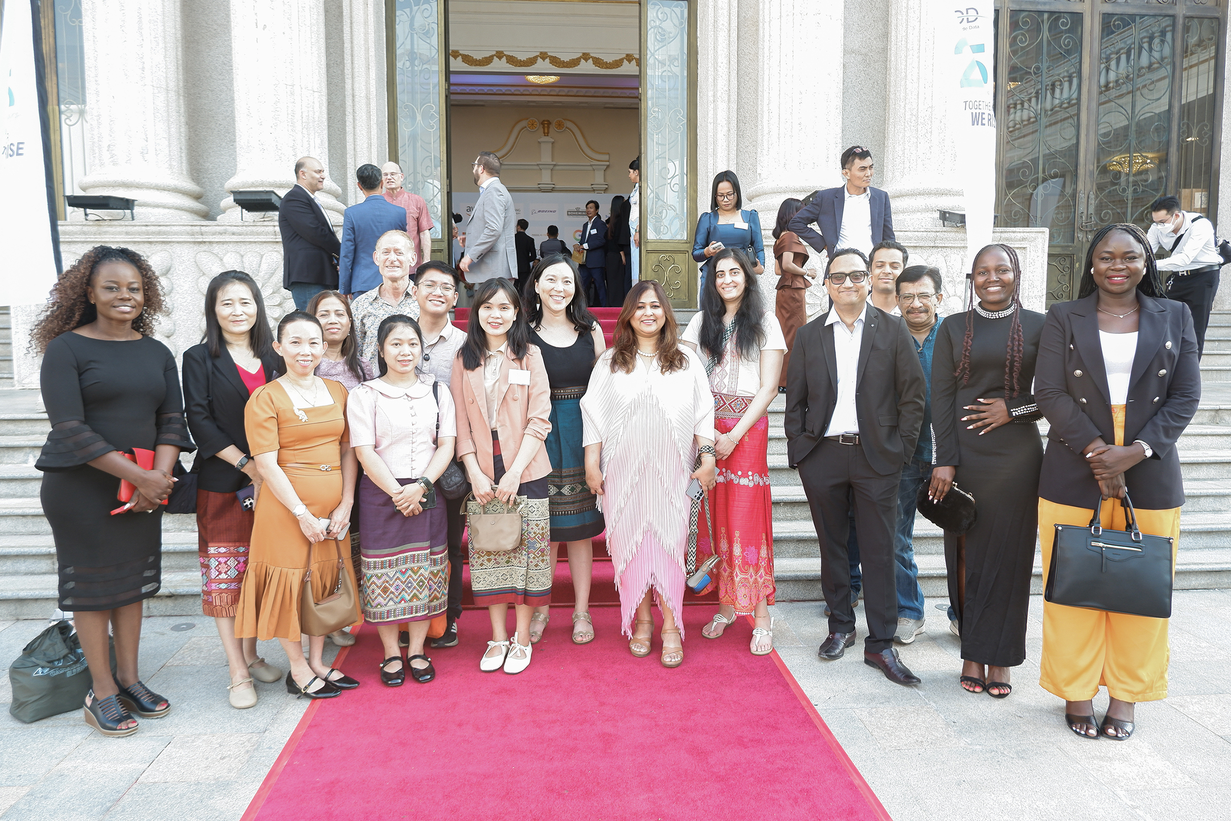 Audience at a panel discussion event on Cambodia's digital future, seated facing a stage with a speaker at a podium and large screens displaying panel information.