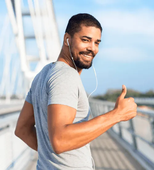 A man walking with headphones, radiating self-assurance thanks to ED treatment