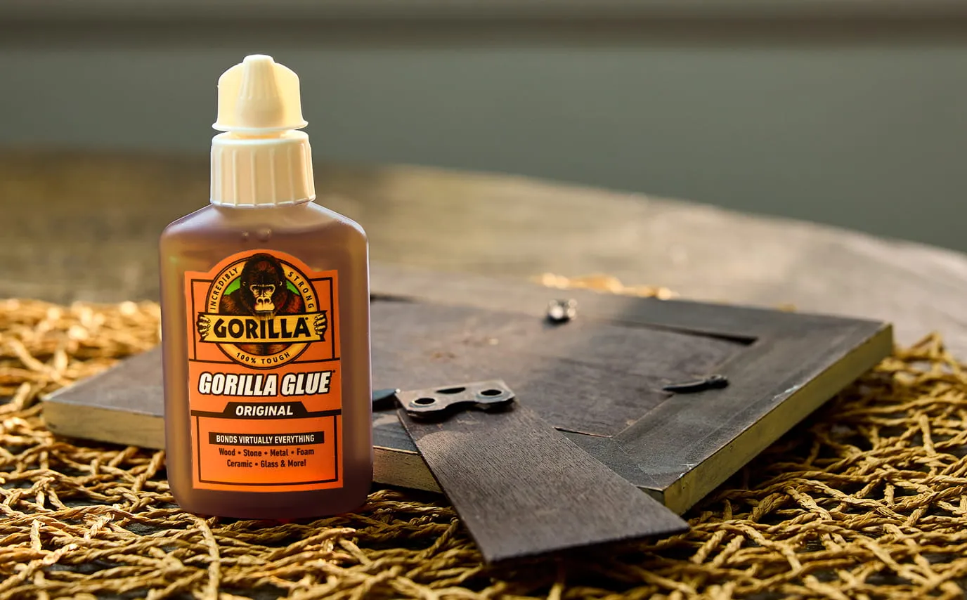 Bottle of Gorilla Glue next to a wooden picture frame.