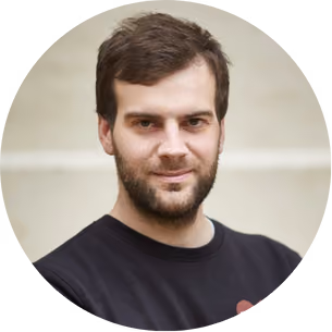 Picture of Jean-Gabriel Goinot: Portrait of a man with brown hair and beard wearing a black shirt, looking at the camera.