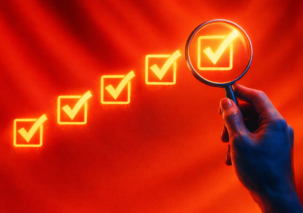 Mano sosteniendo lupa mientras se revisa checklist de marca