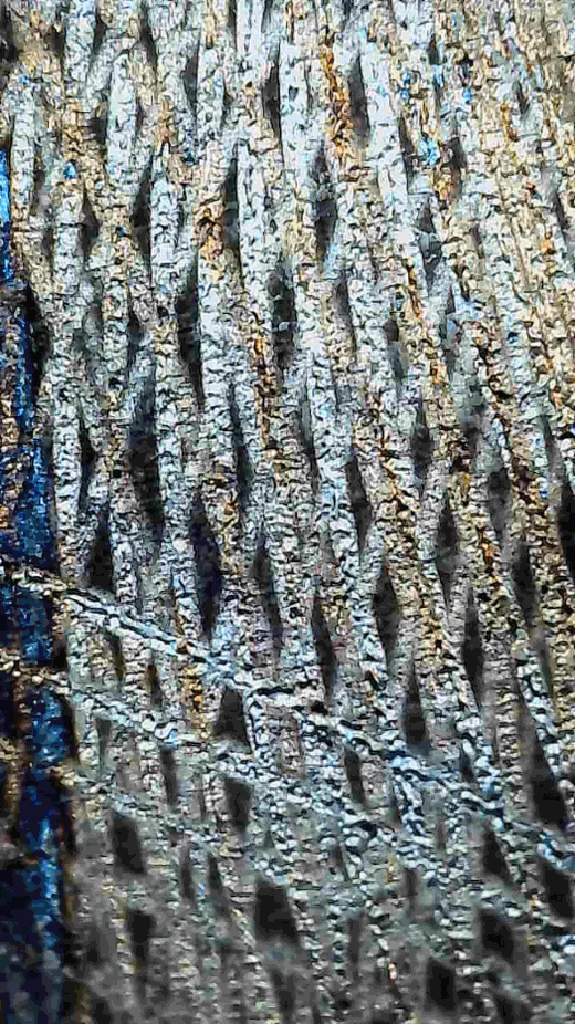 Microscopic view of steel after fiber laser stripping showing clean woven micro-texture for maximum coating adhesion