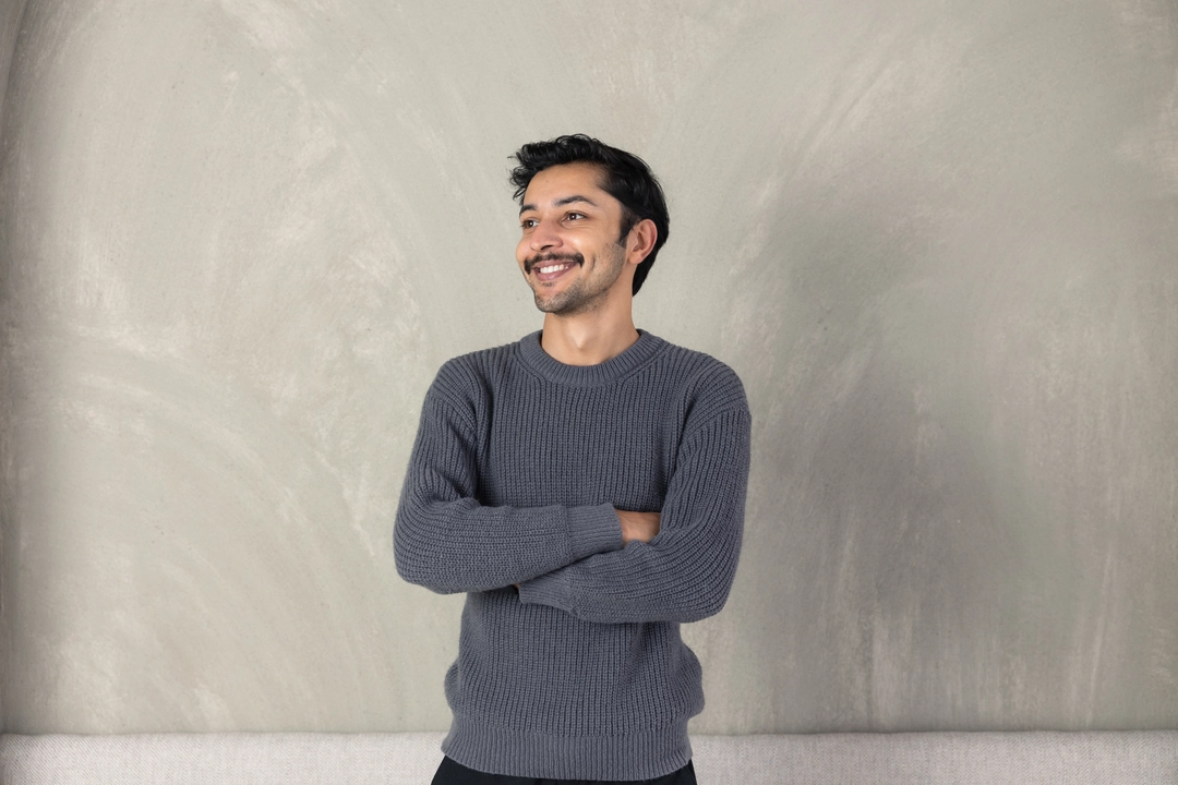 a man smiling with arms crossed