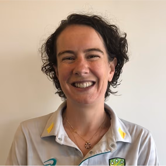 Smiling woman in Australian cricket shirt with two necklaces