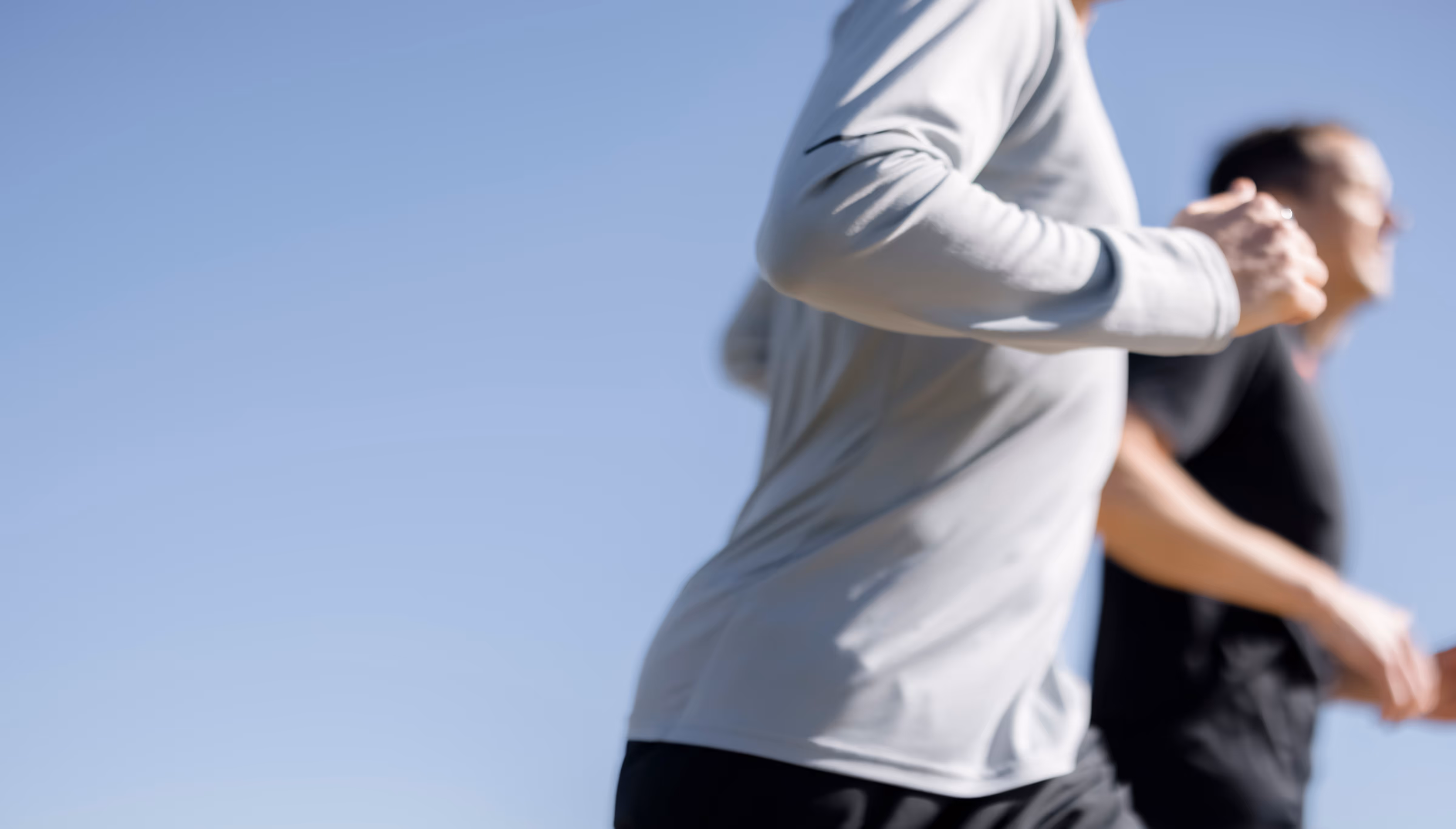 Two people jogging outside on a sunny day; motion blur