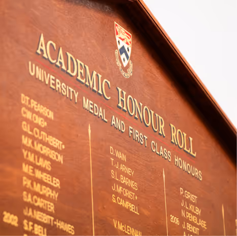 Wooden plaque displaying the Academic Honour Roll with names listed under University Medal and First Class Honours.