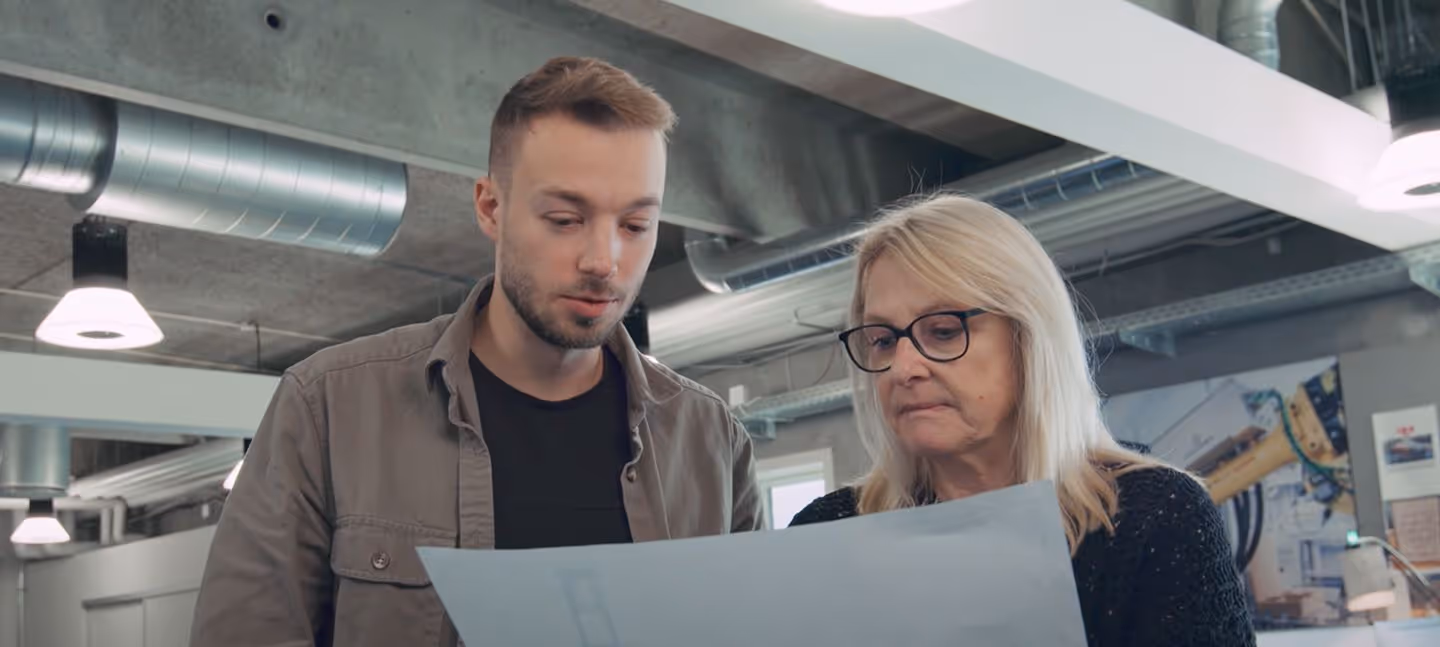A man and a woman looking at a piece of paper.