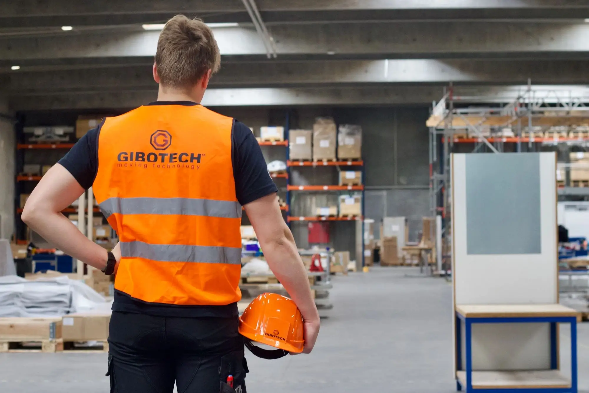 A man wearing an orange safety vest and a hard hat.