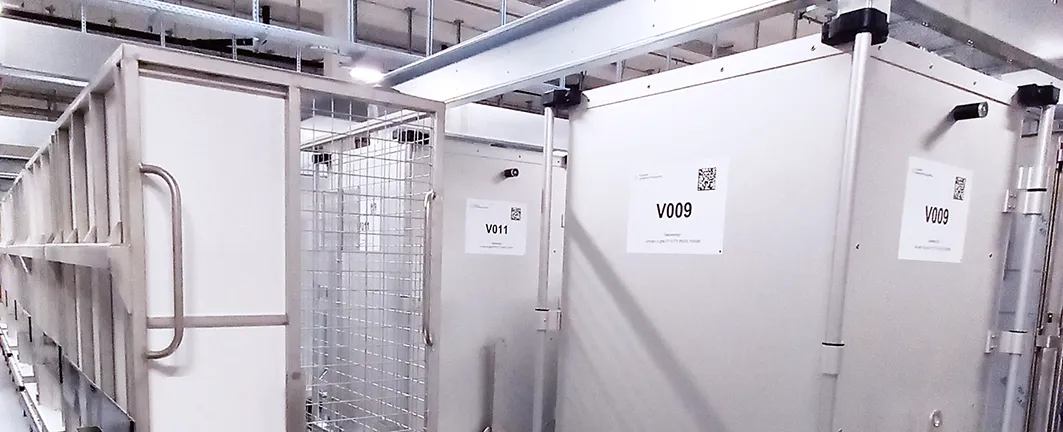 Metall-Aufbewahrungsboxen mit den Kennzeichnungen V009 und V011 in einem Lagerbereich.