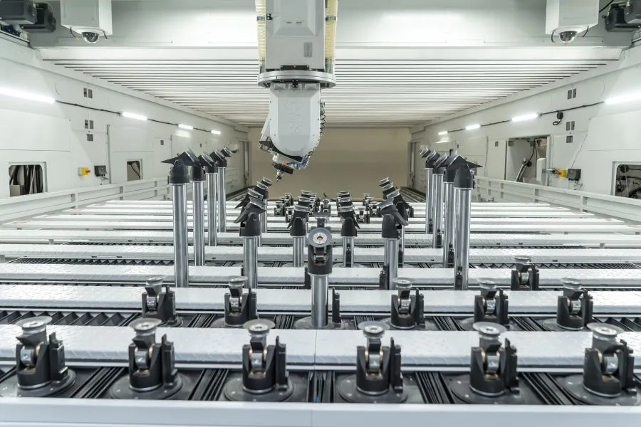 Industrielle CNC-Maschine mit Metallstangen und präzisen automatisierten Werkzeugen in einem hellen Raum.