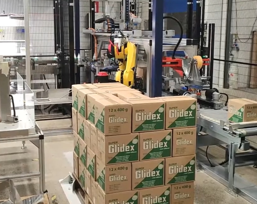 Robot stabler papkasser på palle i Gibotechs pakkeanlæg til Unipak