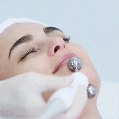 A woman getting a facial peel from a machine.