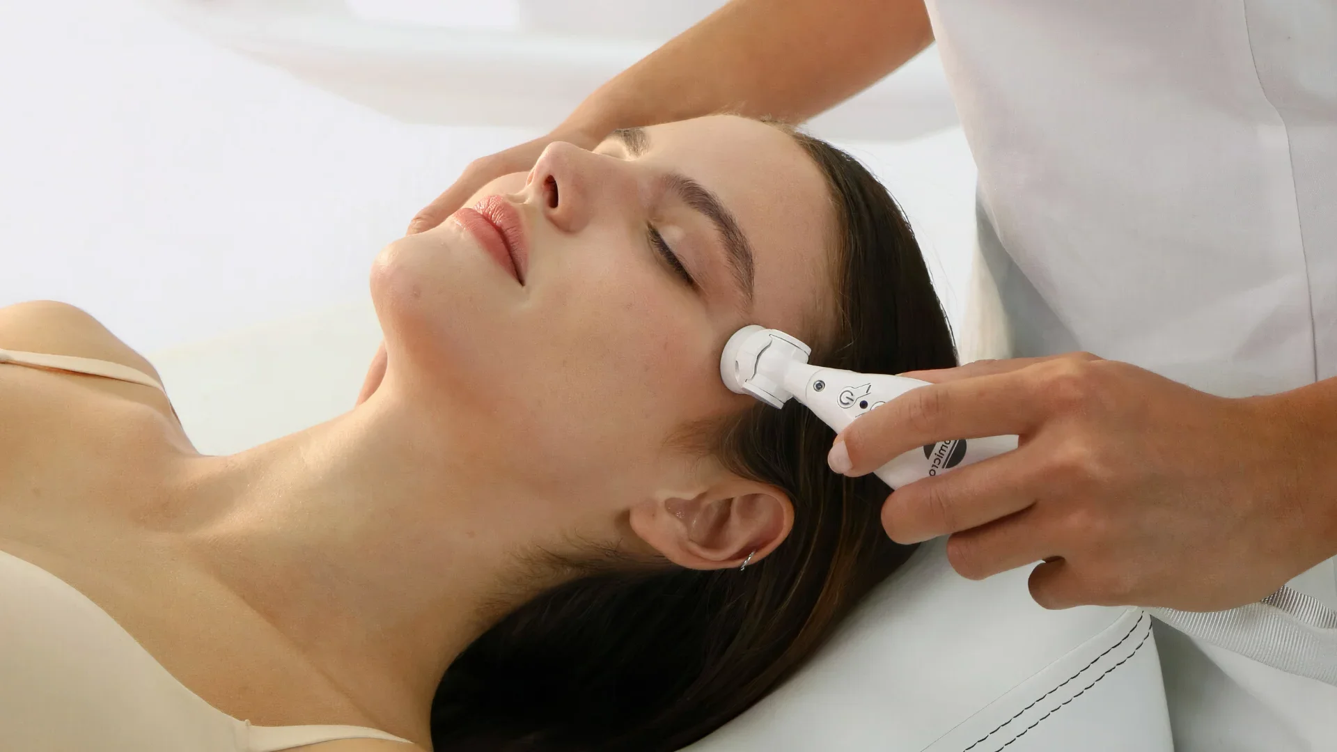 A woman getting a facial massage with an electric device.
