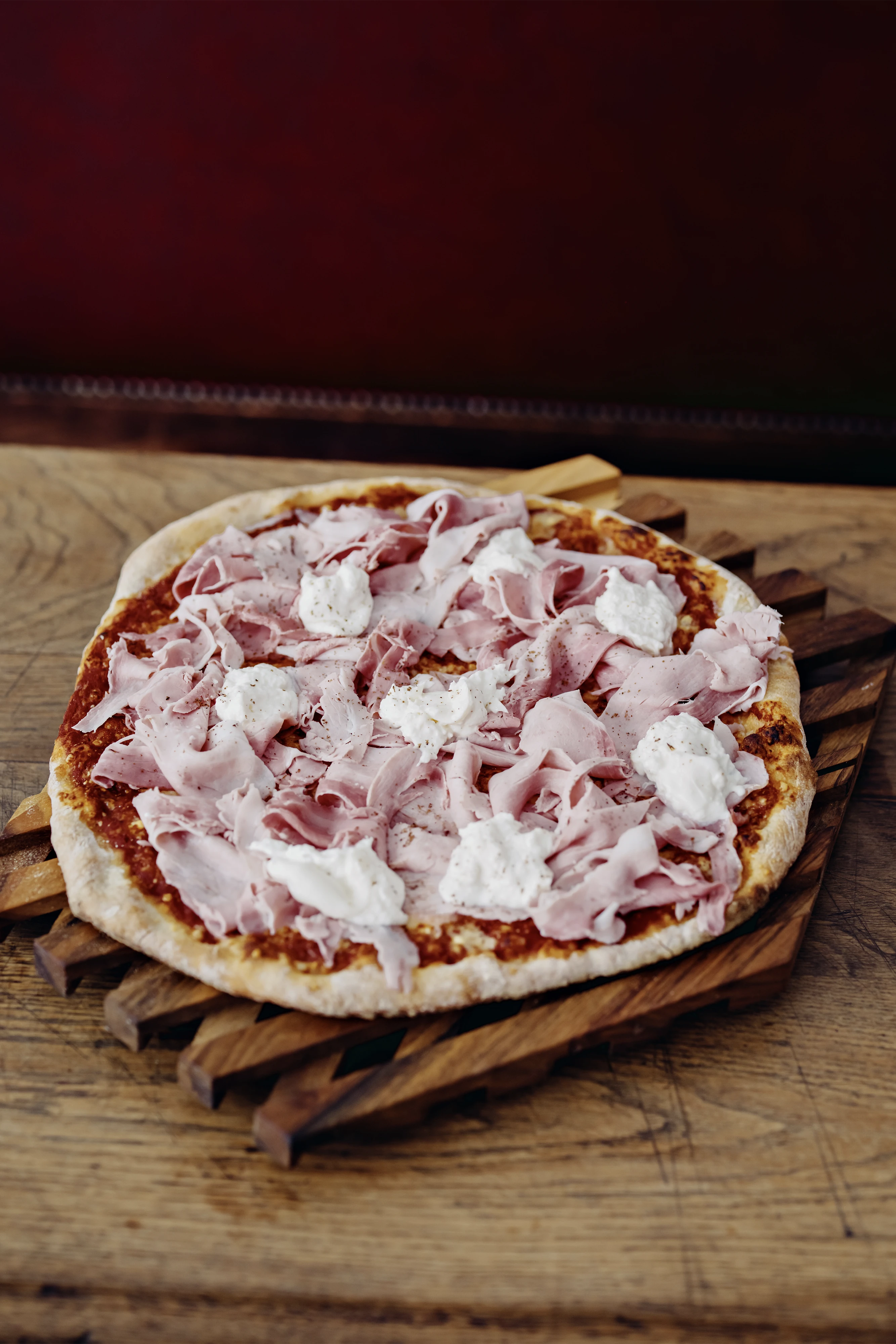 Pizza au prosciutto et burrata crémeuse sur une planche à découper