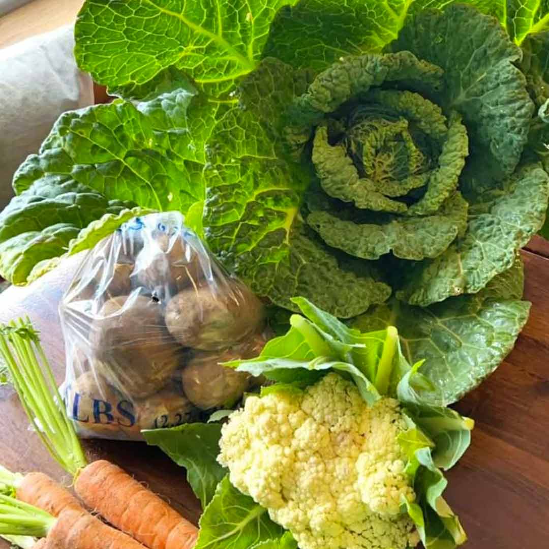 Roots Farm Shop seasonal vegetable on display - Cabbage, new potatoes, cauliflower, and carrots