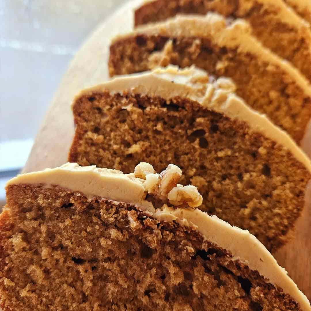 A cake with icing on top and a walnut crown