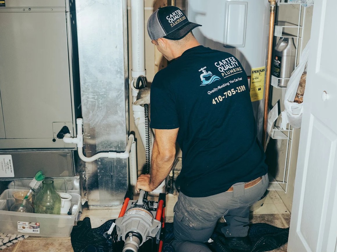 Carter Quality Plumbing technician operating a drain cleaning machine